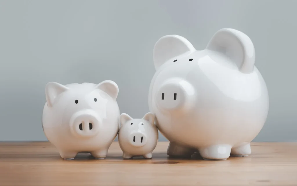 Three white piggy banks sitting on a table.