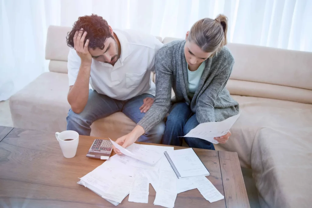 A couple looking at paperwork looking stressed,